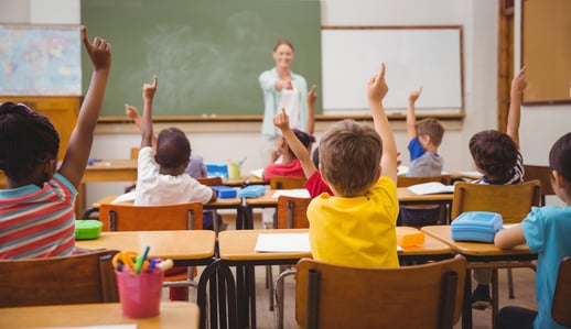 Pupils raising their hands during class at the elementary school